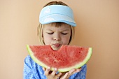 Girl holding slice of melon with a bite taken