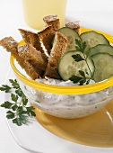 Strips of bread with herb quark and cucumber slices