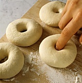 Making bagels: making holes in balls of dough
