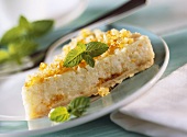 Piece of orange rice tart with mint leaves