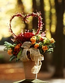 Arrangement of fir with roses &  Erica heart in terracotta pot