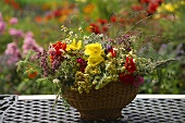 Summer arrangement of flowers and grasses in wicker bowl