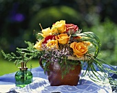 Bouquet of orange and red roses in terracotta vase