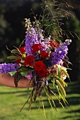 Bouquet of red roses and larkspur