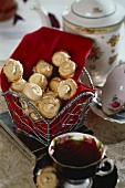 Small meringues in a basket and a cup of tea