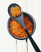 Roter Kaviar im Schälchen und auf Löffel