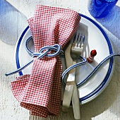 Single place setting with small lighthouse and rope