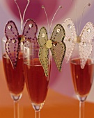 Drei Gläser Kir Royal mit Schmetterlingen dekoriert