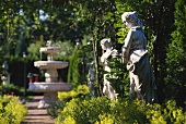 View into a garden with stone fountain and stone figures