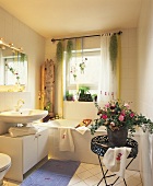 View into bathroom with flower arrangement on tray table and plants in window