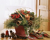 Advent arrangement of poinsettia, juniper and candles