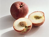 Peach, variety ‘Melida’, whole and halved