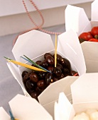 Olives, corncobs and silverskin onions in boxes