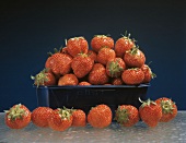 Fresh Strawberries in and Around a Plastic Container