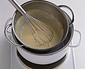 Whisking sauce in bain-marie with whisk