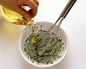 Mixing herb vinaigrette and pouring oil