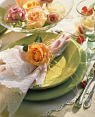 Festive table setting with green plates and roses