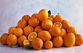 Viele ganze & einige aufgeschnittene Orangen auf einem Haufen