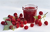 A jar of raspberry jam and raspberries