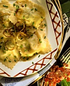 Pasta envelopes with fried onion rings and chives