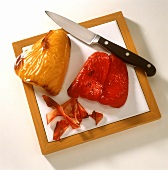 Two Grilled Peppers on a Board with Knife