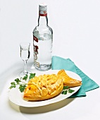 Piroggen (Hefeteigpastete) in Fischform, Flasche & Glas Wodka