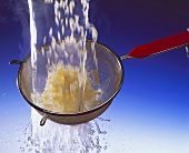 Rinsing rice in a sieve with water