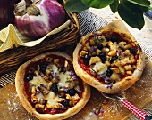 Aubergine pizza with black olives and sage flowers