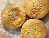 Three double-crust pies with decorative pastry flowers