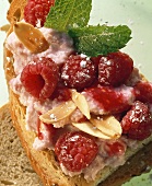 Ricotta & berry spread with almonds & icing sugar on bread