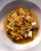Cabbage soup with tomatoes and large cubes of white bread
