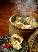 Chinese filled yeast rolls on plate and bamboo steamer