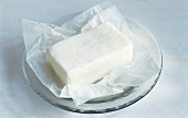 A piece of lard with paper on glass plate