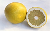 Pomelo, ganz und halbiert, auf hellem Untergrund