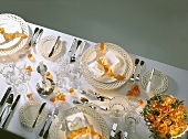 Festive table with white plates, candle, roses