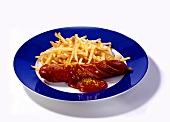 Curry sausage with chips and ketchup on plate