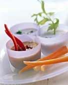 Vegetables (carrots, peppers) with three dips in bowls