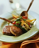 Quark cakes with vegetable salad on plate with salad servers