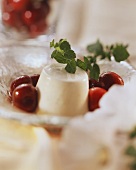 Yoghurt mousse with red wine cherries on glass plate