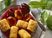 Semolina croquettes with stewed plums on glass plate