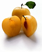 Halved yellow plum with and without stone, whole plum