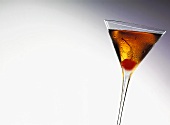 Manhattan Cocktail im Glas mit einer Cocktailkirsche