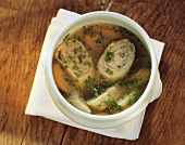 Clear meat soup with forcemeat strudel in soup tureen