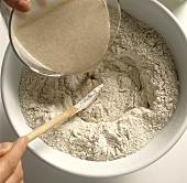 Sauerteig zubereiten: Sauerteig-Ansatz ins Mehl gießen