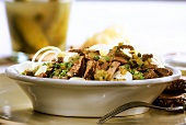 Beef salad with seed oil, gherkins and onions