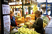 Woman buying peppers in market hall, Budapest