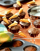 Möhren-Walnuss-Muffins mit Marzipanmöhren auf Kuchengitter