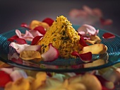 Rice pyramid with pistachios, surrounded by rose petals