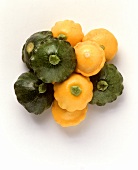 Yellow and green mini-patty pan squashes on white background