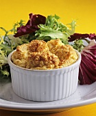 Cheese souffle in baking dish on plate with lettuce garnish